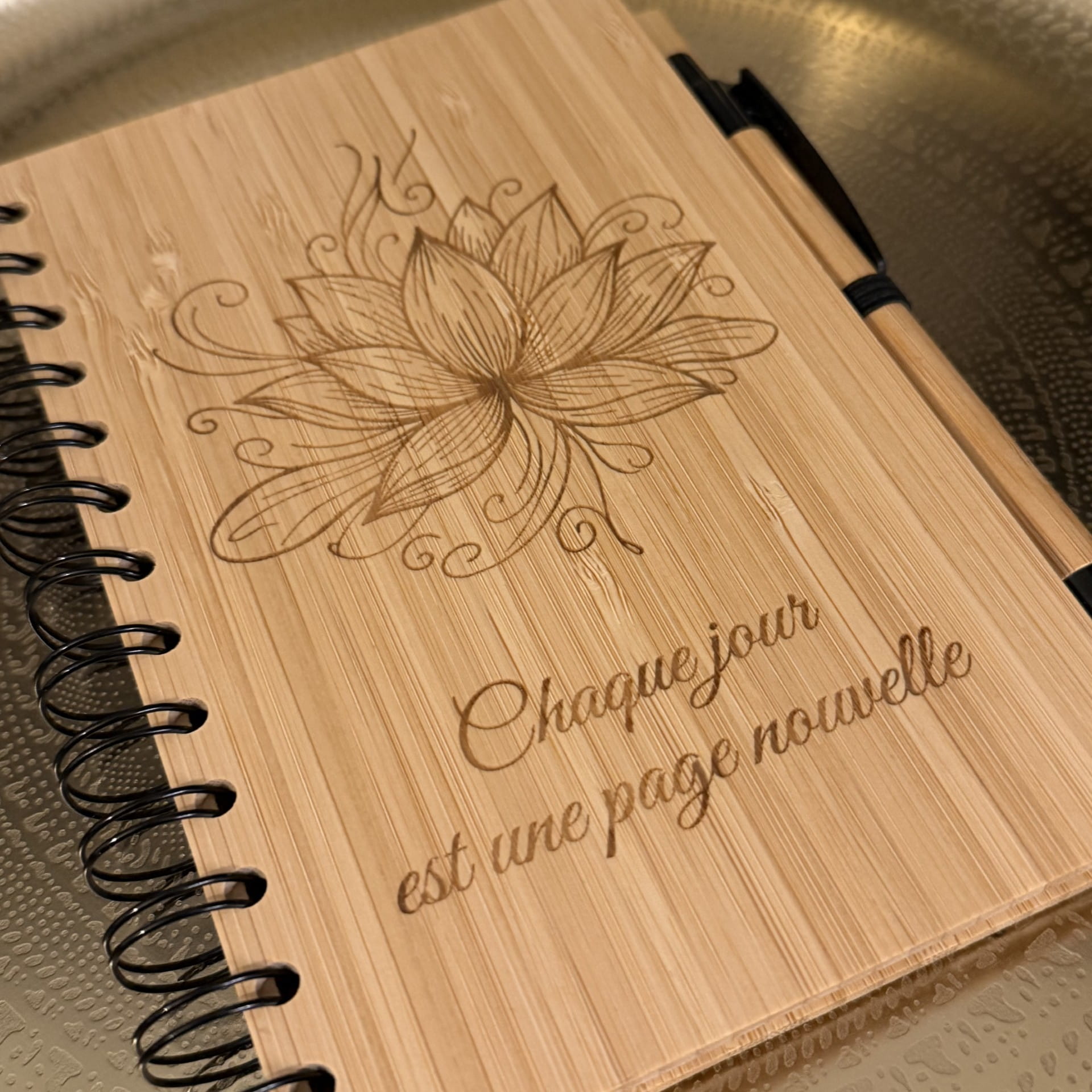 Carnet en bambou gravé fleur de lotus et message "Chaque jour est une page nouvelle"